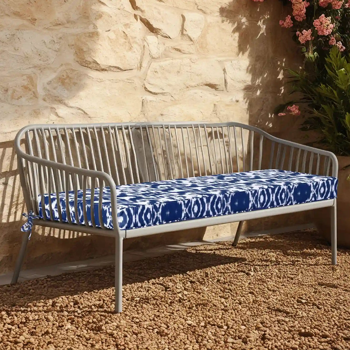 A blue beach & pool cushions placed on the gravel ground